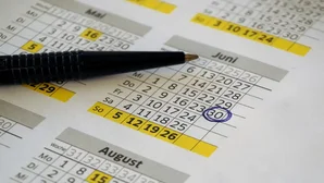 Kalender mit Kugelschreiber, ein Datum im Juni ist blau eingekreist