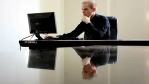 Geschäftsmann sitzt konzentriert an einem Schreibtisch vor einem Computerbildschirm