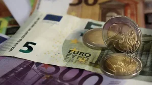 Euro-Geldscheine in verschiedenen Stückelungen mit mehreren Euromünzen darauf